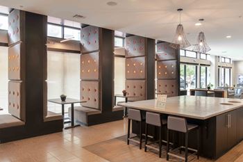 A modern kitchen with a long island and bar stools at Regatta Sloans Lake Apartments, Colorado